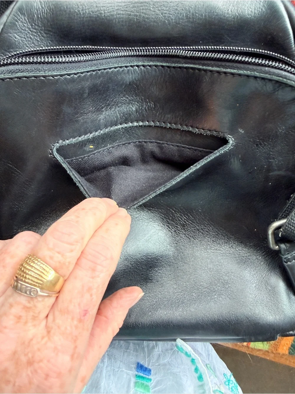 Black trianglular leather backpack with multiple pockets